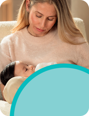 [Translate to Polish (Reborn):] Mother with baby and baby bottle